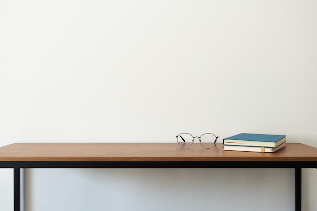Gafas y libros en escritorio de madera interior minimalista Concepto de estudio o de regreso a la escuela