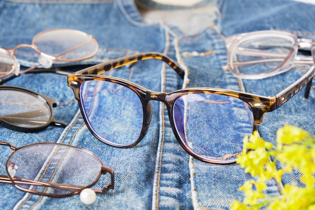 Gafas de moda en una chaqueta de mezclilla, una chaqueta vieja hecha de jeans azules y gafas de ojos múltiples, monturas de anteojos de moda