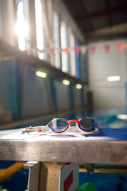 Gafas de natación contra el fondo de una piscina deportiva