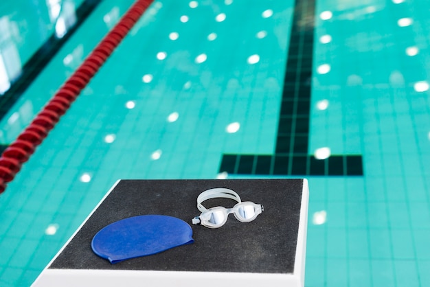 Foto gafas de natación y gorro en la piscina