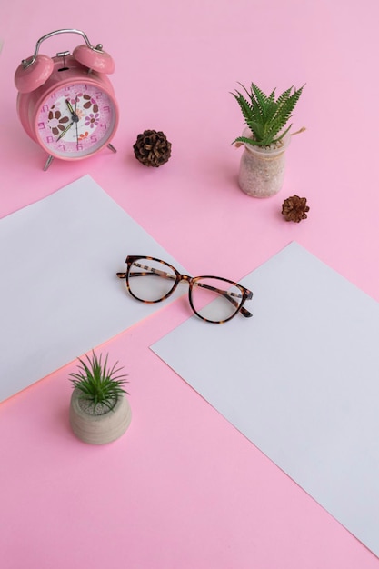 Gafas de ojo de gato en la foto de arriba con un concepto minimalista sobre un fondo de papel morado con decoración de despertador y hojas secas