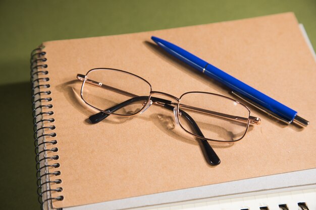 Gafas ópticas en cuadernos de mesa verde