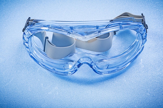 Gafas de plástico de seguridad sobre el concepto de construcción de fondo azul