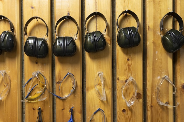 Foto gafas y protección auditiva dispuestas en fila en una galería de tiro