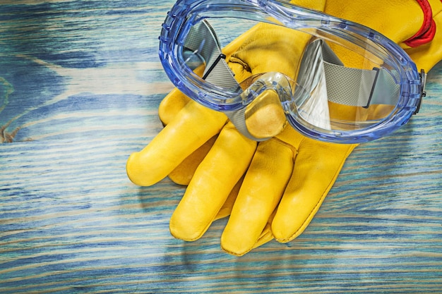 Gafas protectoras de guantes de cuero en concepto de construcción de tablero de madera