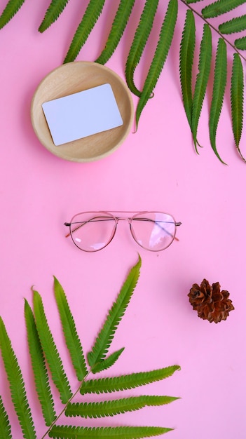 Gafas redondas en la foto de estilo veraniego minimalista sobre un fondo de color rosa pastel.