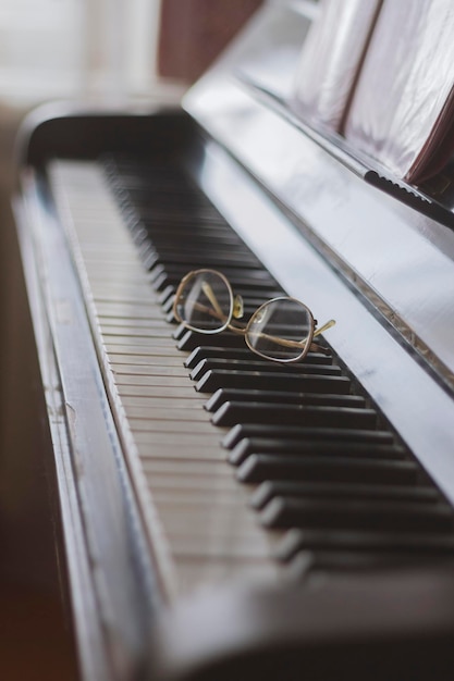 Foto gafas sobre las teclas de un piano, de cerca