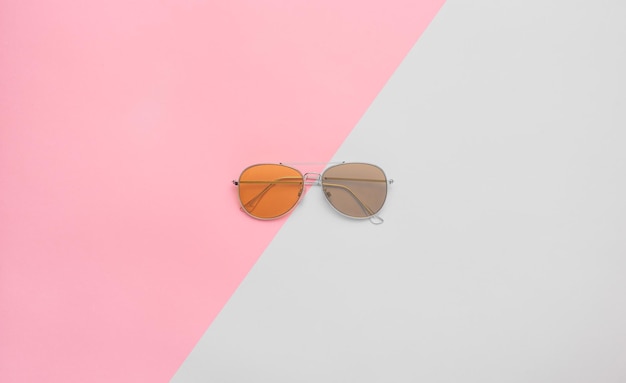 Gafas de sol de aviador de dos colores aviadores sobre fondo rosa y gris Espacio de copia plano