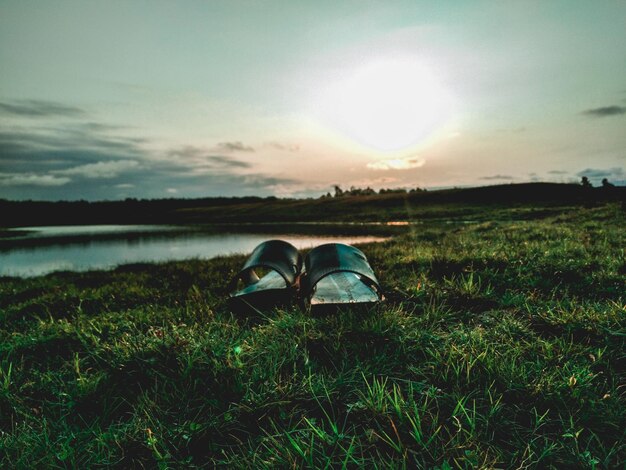 Gafas de sol en el campo contra el cielo durante la puesta de sol