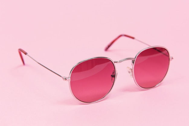 Gafas de sol de color rosa sobre fondo rosa. Aislado en rosa. Moda y estilo