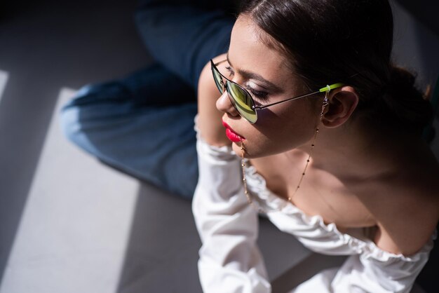 Gafas de sol de moda. Mujer joven con gafas. Chica modelo sensual posando.