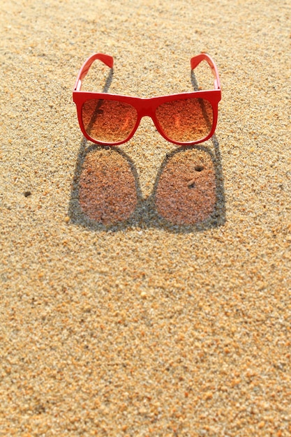 Foto gafas de sol rojas en la playa