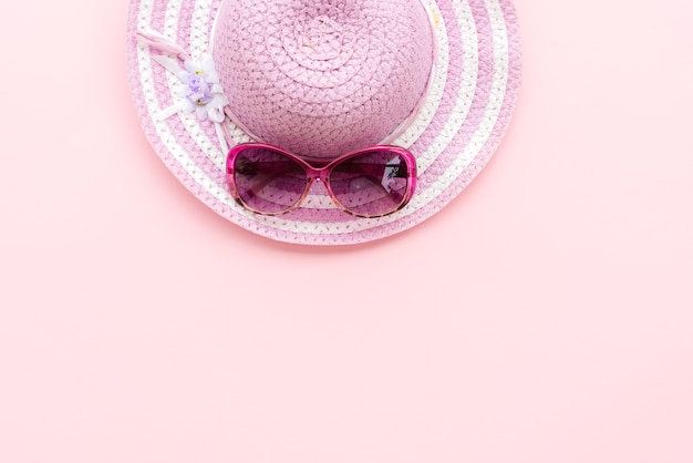 gafas de sol rosadas y sombrero de playa púrpura para las vacaciones de verano y el concepto de vacaciones.