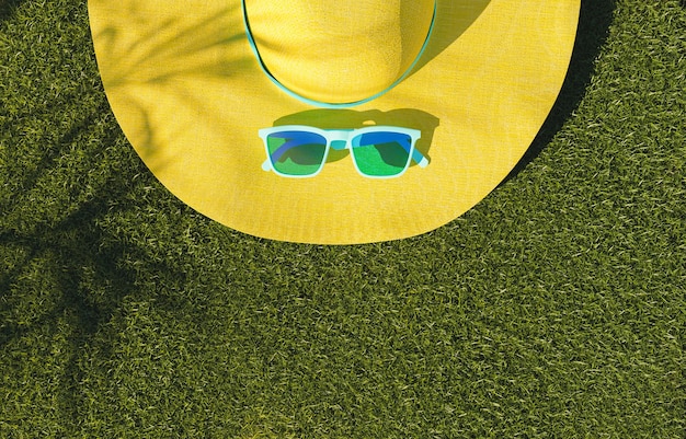 Gafas de sol y sombrero amarillo en concepto de verano de césped