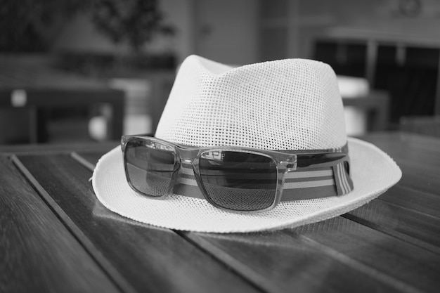 Gafas de sol en el sombrero en la mesa al aire libre