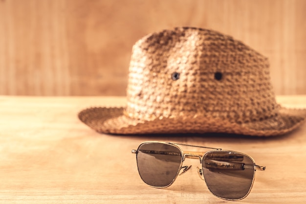 Gafas de sol y sombrero en la mesa de madera