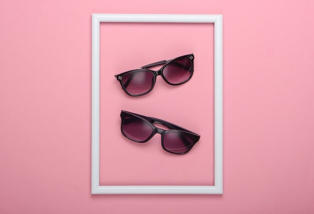 Gafas de sol en superficie rosa con marco blanco