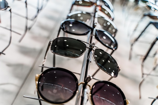 Gafas de sol en una tienda Fila de anteojos de lujo en una tienda de óptica