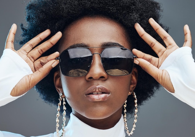 Gafas de sol con zoom facial y moda con estilo de mujer negra y diseñadora con marca de moda y manos de la generación z contra el fondo del estudio Joyería vanguardista y marketing de chicas con modelo de moda y belleza