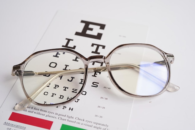 Foto gafas en la tabla de examen ocular para probar la precisión de la vista de la lectura