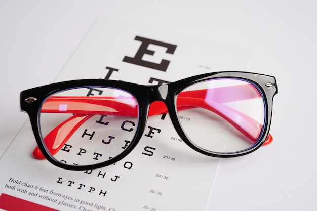 Gafas en la tabla de examen de la vista para probar la precisión de la lectura