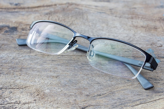 Las gafas yacen en la mesa de madera oscura.