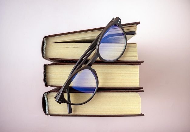 Las gafas yacen en la vista superior de los libros