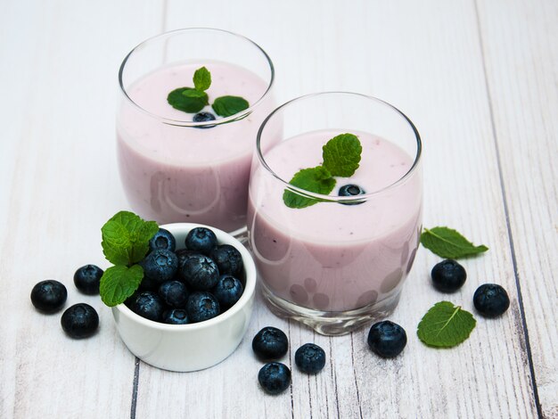 Gafas con yogur de arándanos en una mesa