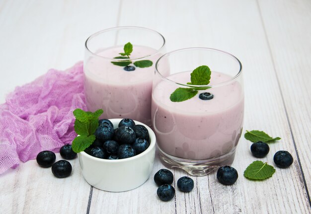 Gafas con yogur de arándanos en una mesa