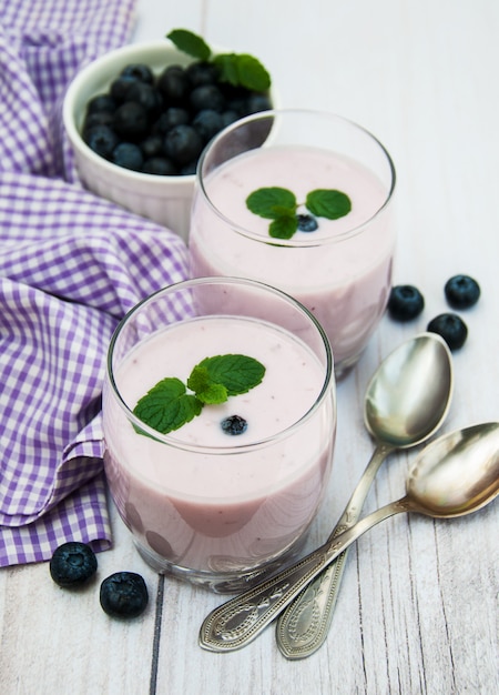 Gafas con yogur de arándanos en una mesa