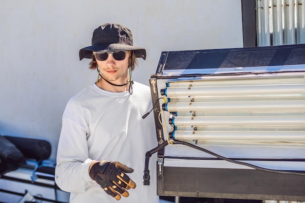 Gaffer ou o eletricista-chefe em uma unidade de produção de cinema ou televisão monta as luzes e o suporte de luz em uma filmagem comercial