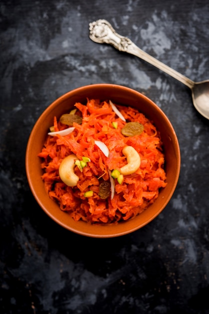 Gajar ka halwa es un pudín de postre dulce a base de zanahoria de la India. Adornado con nueces de anacardo. servido en un bol.