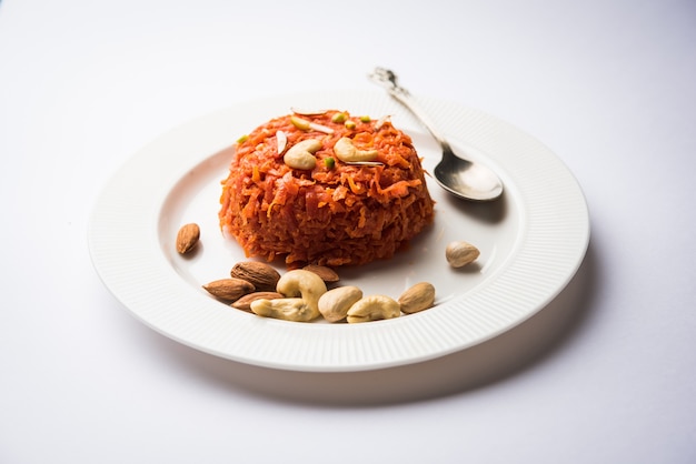 Gajar ka halwa es un pudín de postre dulce a base de zanahoria de la India. Adornado con nueces de anacardo. servido en un bol.