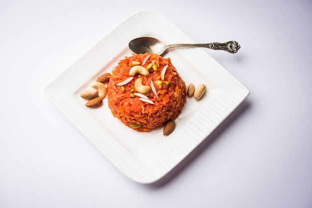 Gajar ka halwa ist ein süßer Dessertpudding auf Karottenbasis aus Indien. Garniert mit Cashew-Mandelnüssen. in einer Schüssel serviert.