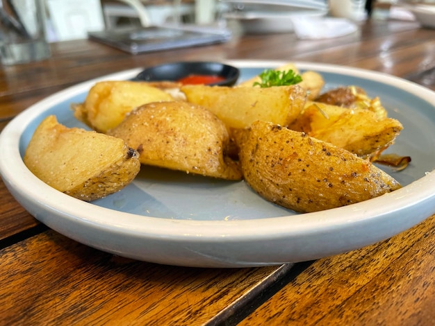 Gajos de patata al horno con cebolla rallada y salsa de hierbas y tomate