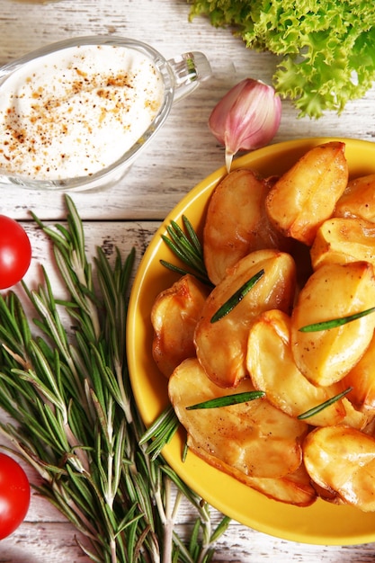 Gajos de patata al horno en primer plano de la mesa de madera