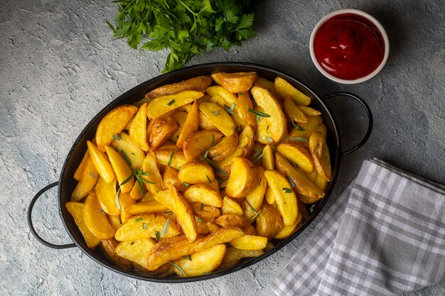 Gajos de patata asada con hierbas y sal marina en el plato, vista superior (nombre turco; patatas de elma dilim)