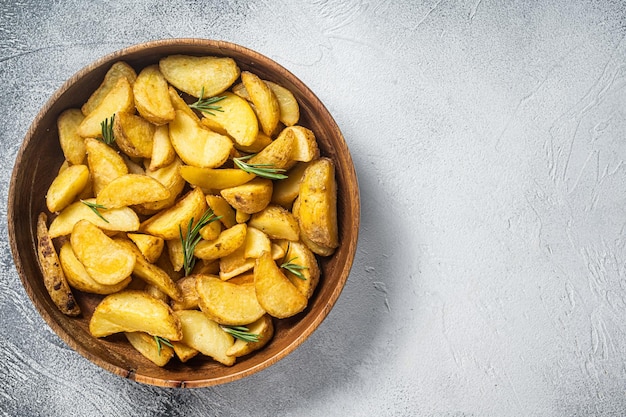 Gajos de patata asada con romero orgánico vegetariano comida de gajos de patata Fondo blanco Vista superior Espacio de copia