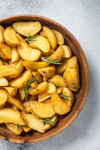 Gajos de patata asada con romero vegetariano orgánico comida de gajos de patata Fondo blanco Vista superior