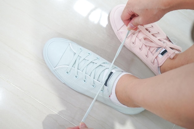 Gal prueba las zapatillas de deporte con tonos pastel y color en una zapatería deportiva y de moda