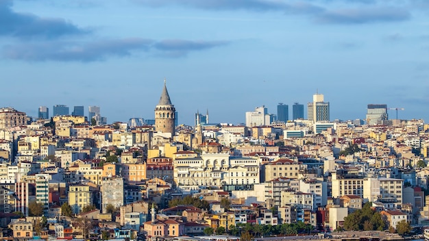 Galata Tower mit Ebenen von Wohngebäuden davor und modernen Gebäuden bei bewölktem Wetter Istanbul, Türkei