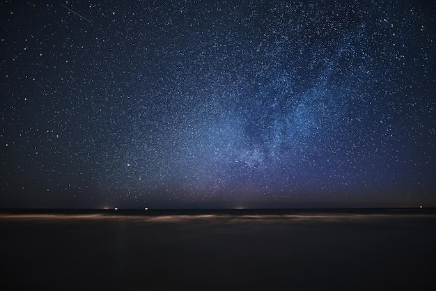 Galaxia de la Vía Láctea en una playa de arena Observación de estrellas durante las vacaciones de verano al aire libre en la playa