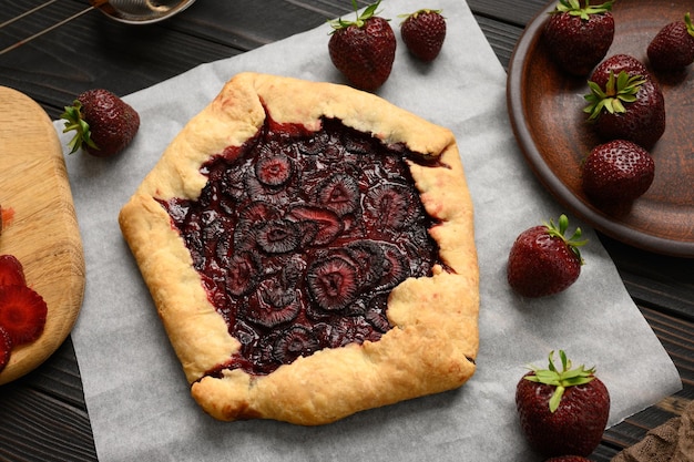 Galette de morango em fundo escuro de madeira caseiro