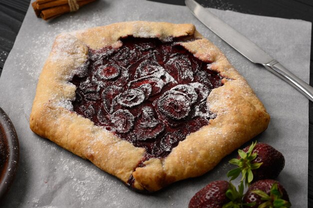 Galette de morango em fundo escuro de madeira caseiro