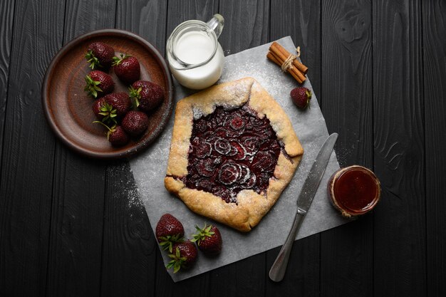 Galette de morango em fundo escuro de madeira caseiro