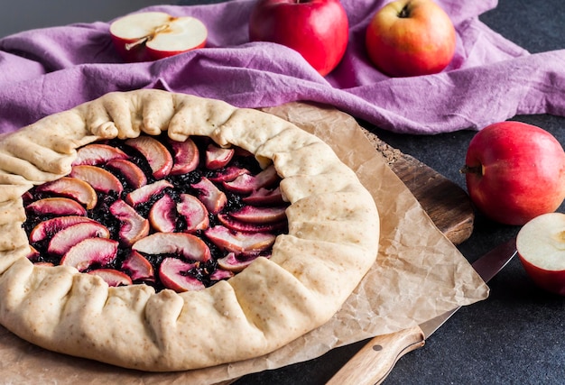 Galette dulce cuaresmal con manzanas y bayas de saúco en tablero woden