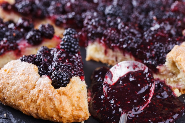 Galette con moras sobre un fondo negro.