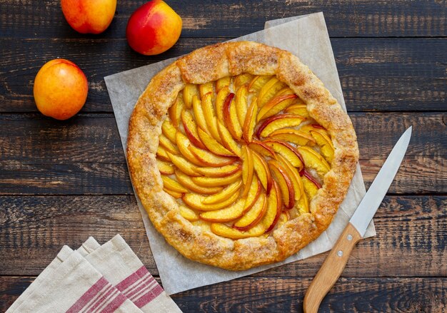 Galette o tarta abierta con melocotones. Horneando. Comida vegetariana.