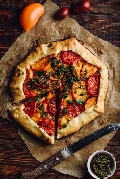 Foto galette de tomate en rodajas sobre papel de horno