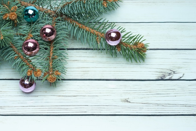 Galho de árvore de abeto de Natal com decoração em fundo branco de tábua de madeira